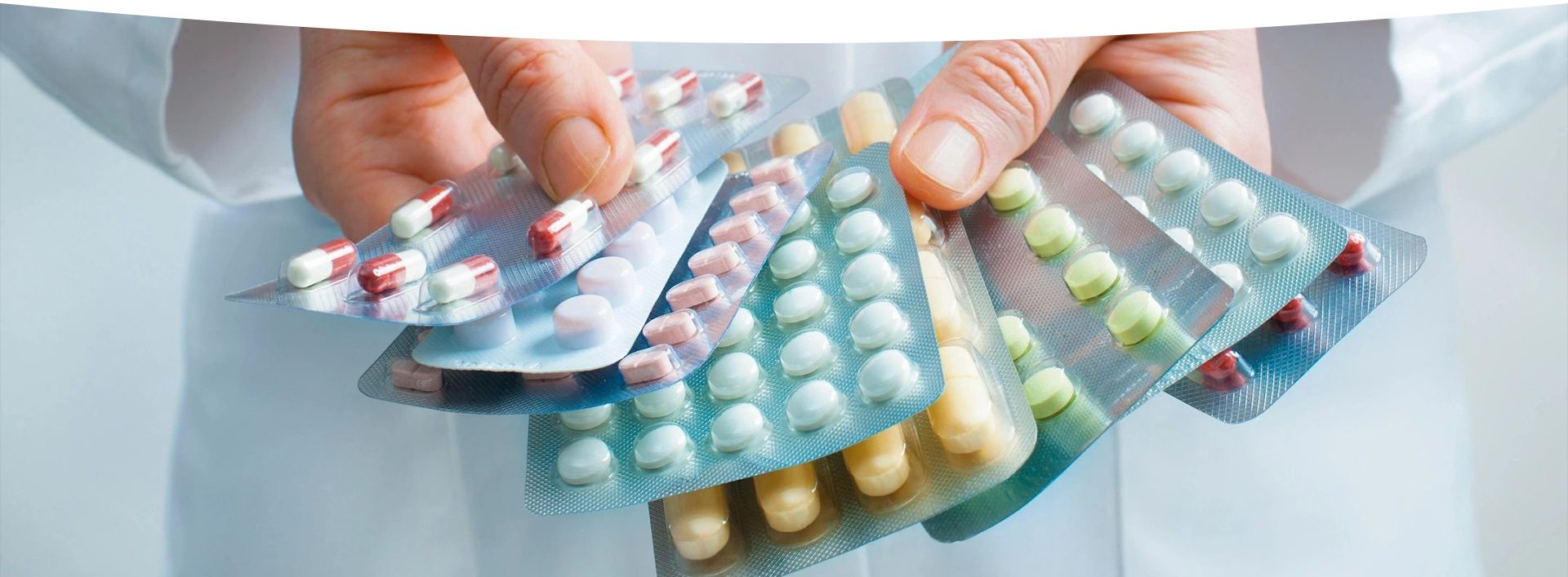 A person holding onto several different types of pills.