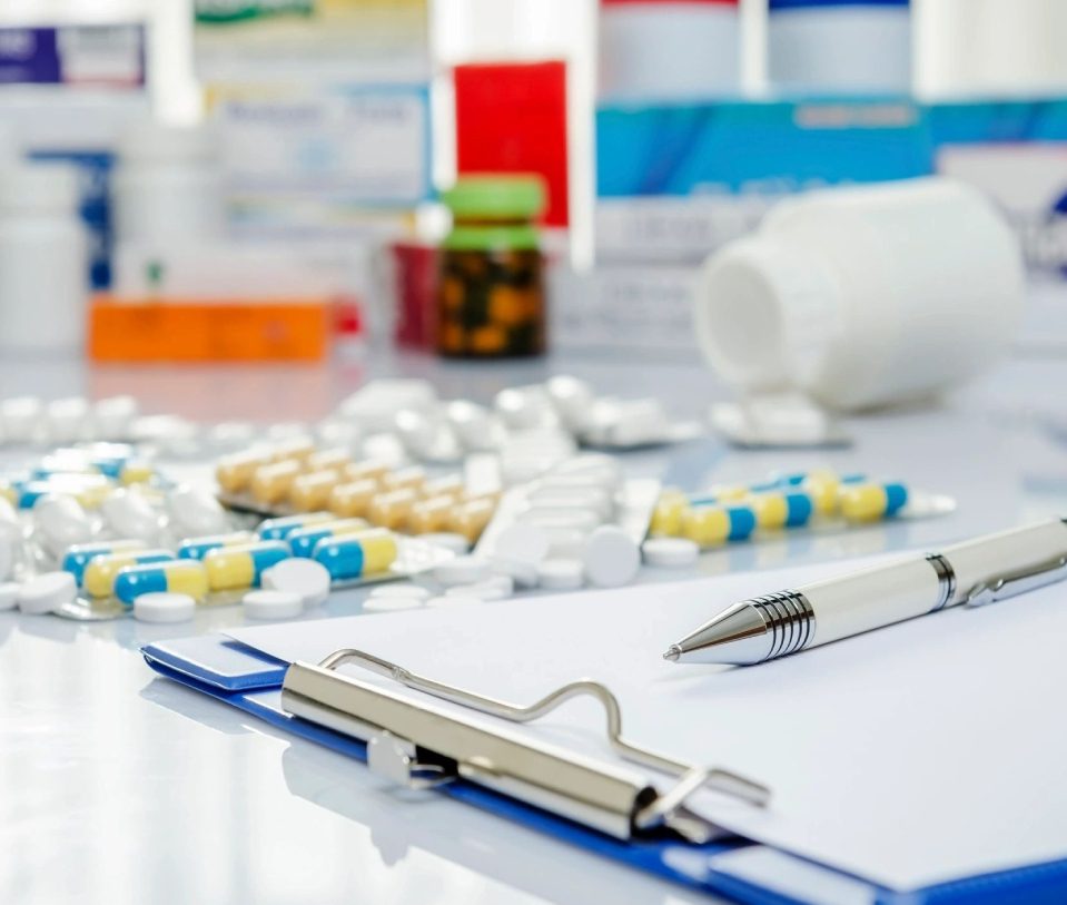 A table with many different pills and pens